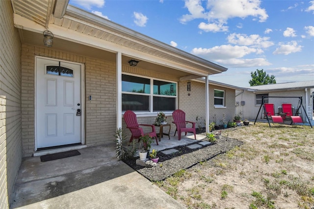 7830 Ilex Dr, Port Richey, FL 34668 - entrance to property featuring brick siding and a porch