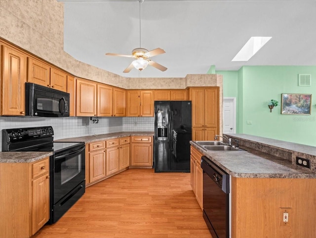 10442 Ventura Dr, Spring Hill, FL 34608 - kitchen with black appliances, a sink, a skylight, light wood-type flooring, and backsplash