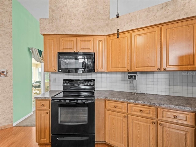 10442 Ventura Dr, Spring Hill, FL 34608 - kitchen featuring black appliances, light wood-style flooring, decorative backsplash, and dark countertops