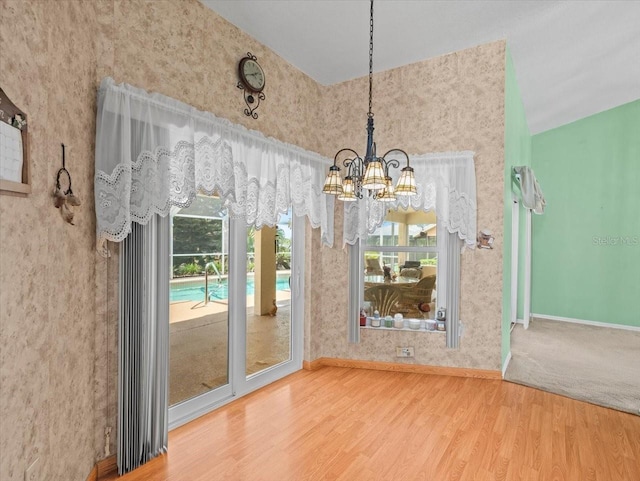 10442 Ventura Dr, Spring Hill, FL 34608 - unfurnished dining area featuring a chandelier, wood finished floors, and baseboards