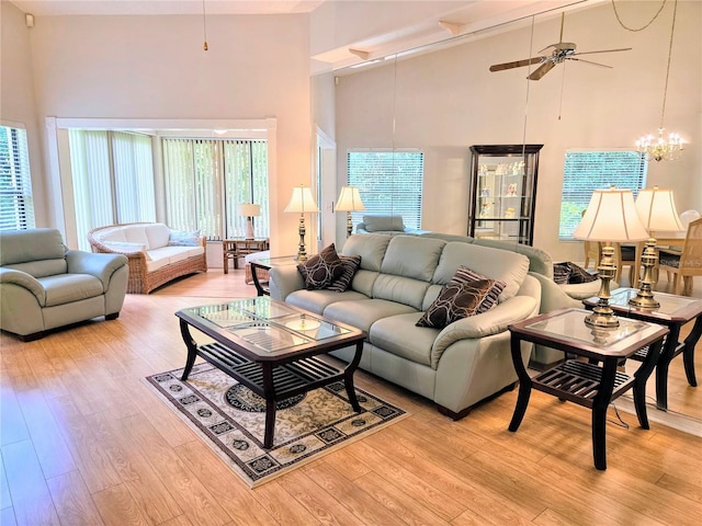 3627 Muirfield Ct Unit 3627, New Port Richey, FL 34655 - living room featuring high vaulted ceiling, ceiling fan, light wood-type flooring, and a chandelier