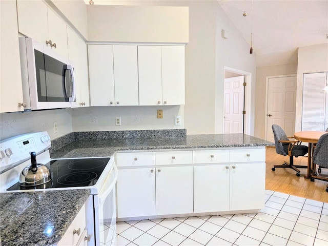 3627 Muirfield Ct Unit 3627, New Port Richey, FL 34655 - kitchen featuring white appliances, lofted ceiling, white cabinetry, and a peninsula
