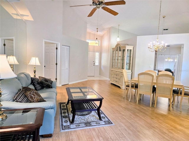 3627 Muirfield Ct Unit 3627, New Port Richey, FL 34655 - living area with a chandelier, ceiling fan, light wood-style flooring, high vaulted ceiling, and baseboards