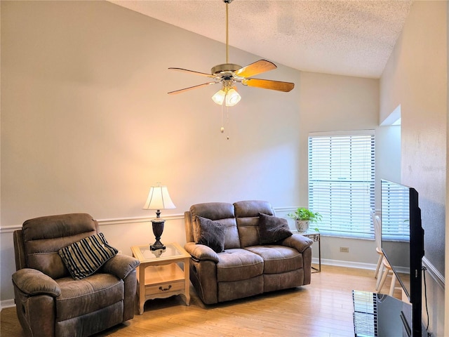 3627 Muirfield Ct Unit 3627, New Port Richey, FL 34655 - living area featuring a textured ceiling, a ceiling fan, light wood-style flooring, baseboards, and high vaulted ceiling