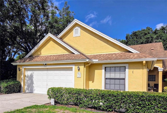 3627 Muirfield Ct Unit 3627, New Port Richey, FL 34655 - view of front of house featuring stucco siding, roof with shingles, a garage, and driveway