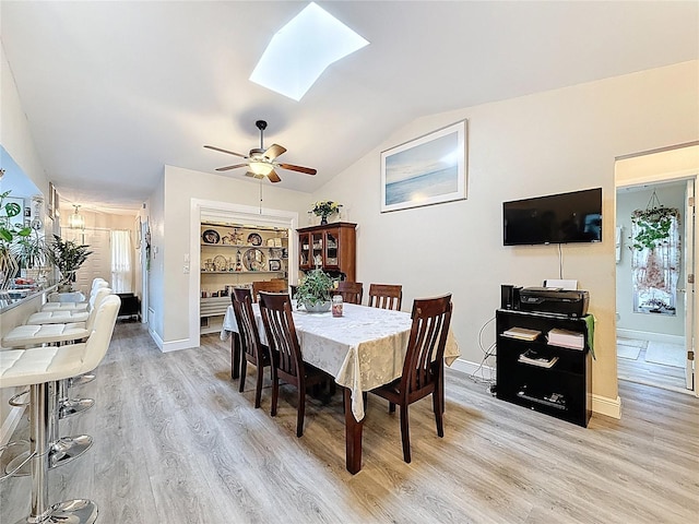 10411 Ireland St, Spring Hill, FL 34608 - dining space featuring light wood finished floors, a skylight, lofted ceiling, baseboards, and a ceiling fan