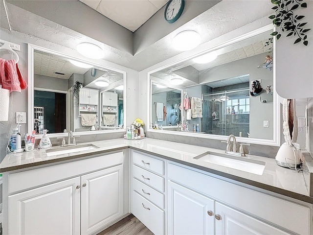 10411 Ireland St, Spring Hill, FL 34608 - full bath with double vanity, a stall shower, and wood finished floors