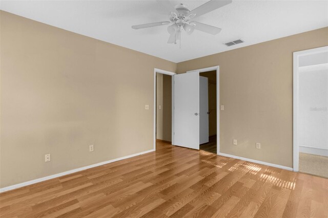 4221 San Rafael Ave, New Port Richey, FL 34655 - unfurnished bedroom with light wood finished floors, baseboards, a walk in closet, and a ceiling fan