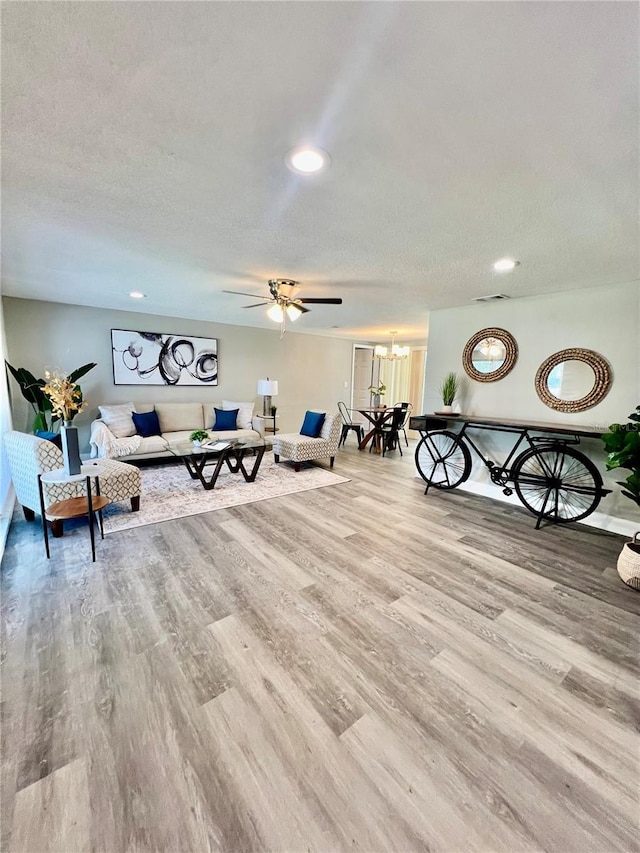 3304 Honeymoon Ln, Holiday, FL 34691 - living room with wood finished floors, a ceiling fan, recessed lighting, a textured ceiling, and a chandelier