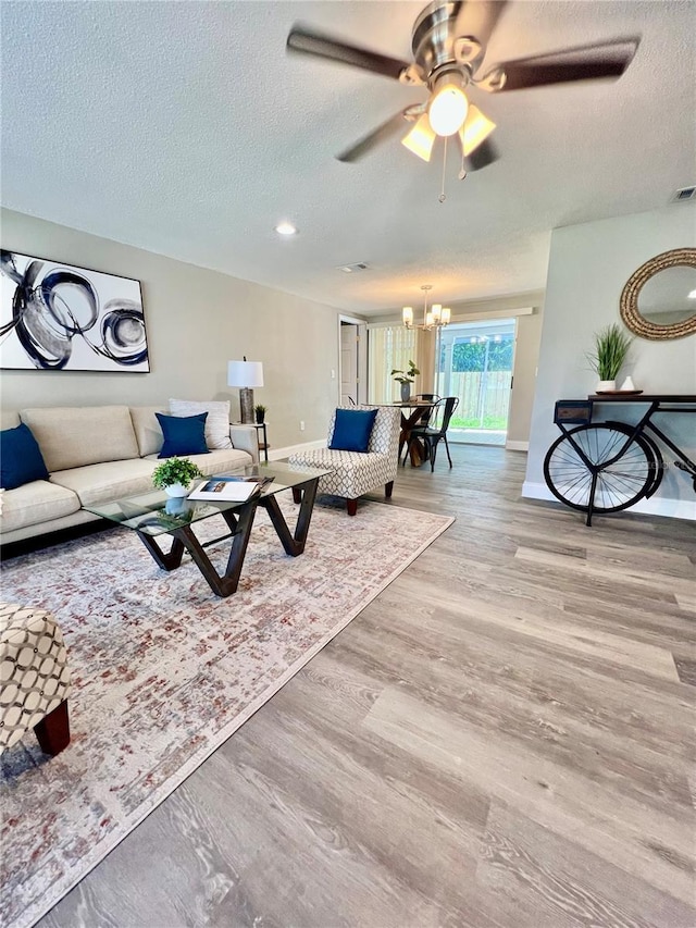 3304 Honeymoon Ln, Holiday, FL 34691 - living room featuring a chandelier, baseboards, a textured ceiling, wood finished floors, and ceiling fan