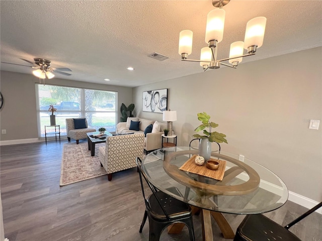 3304 Honeymoon Ln, Holiday, FL 34691 - dining room with a textured ceiling, baseboards, dark wood finished floors, a chandelier, and a ceiling fan