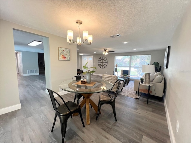 3304 Honeymoon Ln, Holiday, FL 34691 - dining area with a chandelier, wood finished floors, baseboards, a textured ceiling, and a ceiling fan