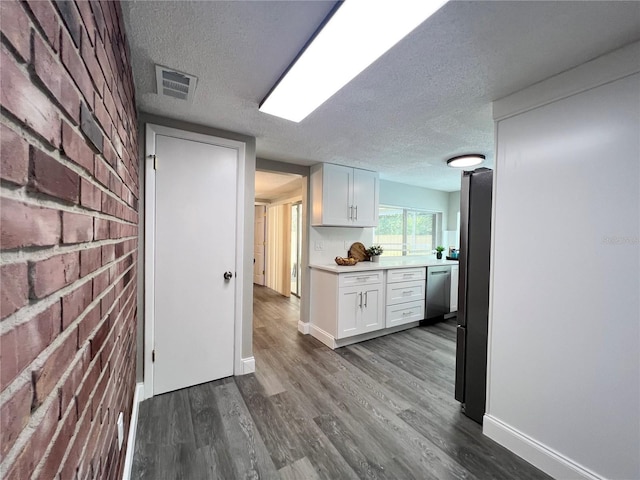 3304 Honeymoon Ln, Holiday, FL 34691 - kitchen with a textured ceiling, white cabinetry, dark wood-type flooring, dishwasher, and light countertops