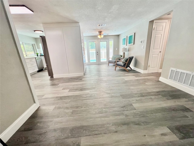 3304 Honeymoon Ln, Holiday, FL 34691 - hall featuring baseboards, plenty of natural light, wood finished floors, and a textured ceiling