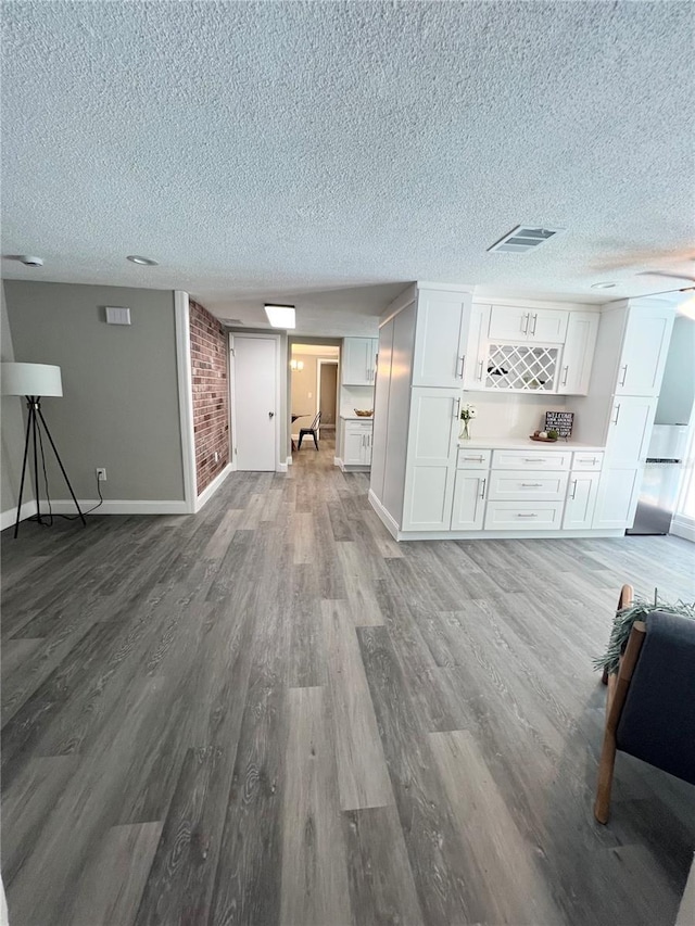 3304 Honeymoon Ln, Holiday, FL 34691 - living room featuring a textured ceiling, wood finished floors, baseboards, and a dry bar