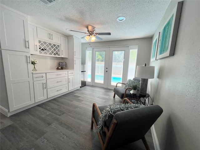 3304 Honeymoon Ln, Holiday, FL 34691 - sitting room with french doors, a textured ceiling, dark wood finished floors, a ceiling fan, and a bar