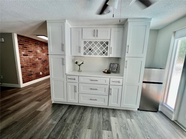 3304 Honeymoon Ln, Holiday, FL 34691 - bar area featuring brick wall, a ceiling fan, baseboards, wood finished floors, and a textured ceiling