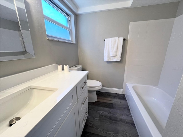 3304 Honeymoon Ln, Holiday, FL 34691 - bathroom featuring vanity, toilet, baseboards, and wood finished floors