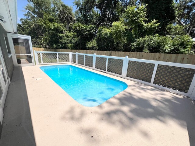 3304 Honeymoon Ln, Holiday, FL 34691 - view of swimming pool with a fenced backyard, a patio, and view of scattered trees