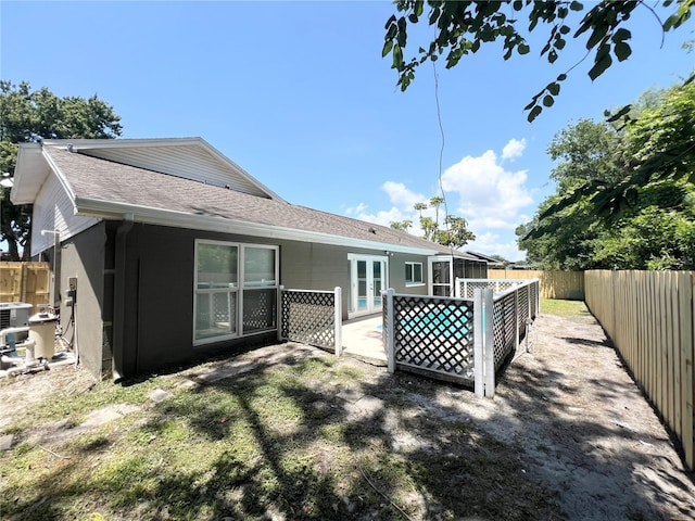 3304 Honeymoon Ln, Holiday, FL 34691 - rear view of property featuring a fenced backyard, a shingled roof, and a sunroom