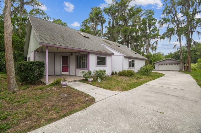 8755 Marigold Dr, New Port Richey, FL 34654 - single story home featuring an outdoor structure, a detached garage, a shingled roof, and covered porch