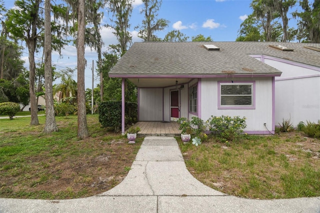 8755 Marigold Dr, New Port Richey, FL 34654 - view of front of house featuring a shingled roof, a porch, and a front lawn