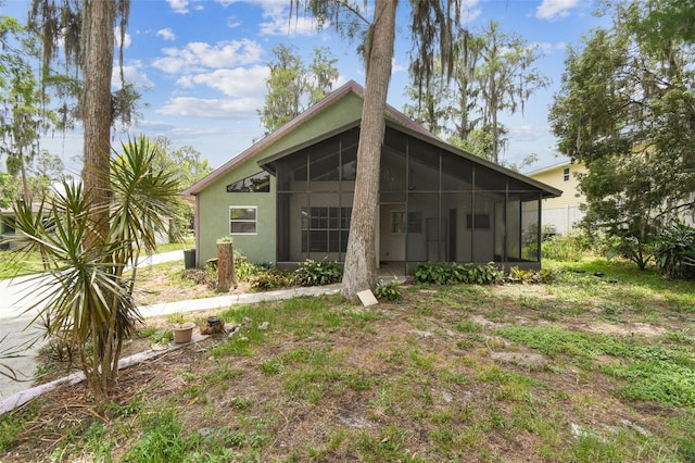 8755 Marigold Dr, New Port Richey, FL 34654 - rear view of property with a sunroom and stucco siding