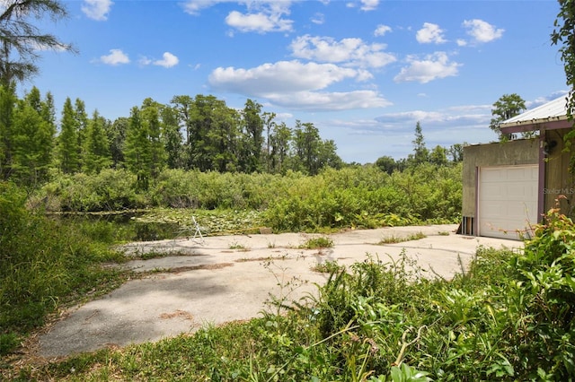 8755 Marigold Dr, New Port Richey, FL 34654 - view of yard featuring concrete driveway and a garage
