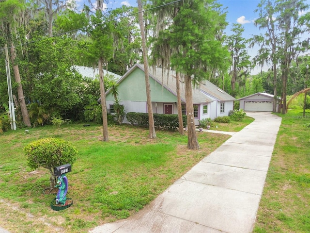 8755 Marigold Dr, New Port Richey, FL 34654 - view of front facade featuring an outdoor structure, a detached garage, a front lawn, and stucco siding