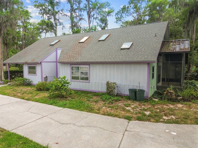 8755 Marigold Dr, New Port Richey, FL 34654 - view of front of property featuring a shingled roof and a sunroom