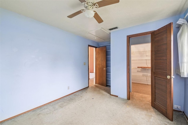 8755 Marigold Dr, New Port Richey, FL 34654 - unfurnished bedroom with light carpet, attic access, a closet, a walk in closet, and baseboards