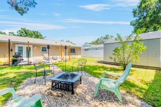 6656 Pinecrest Ln N, Pinellas Park, FL 33781 - view of grassy yard featuring a fire pit and a patio area