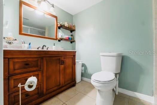6656 Pinecrest Ln N, Pinellas Park, FL 33781 - bathroom with toilet, vanity, tile patterned flooring, and baseboards
