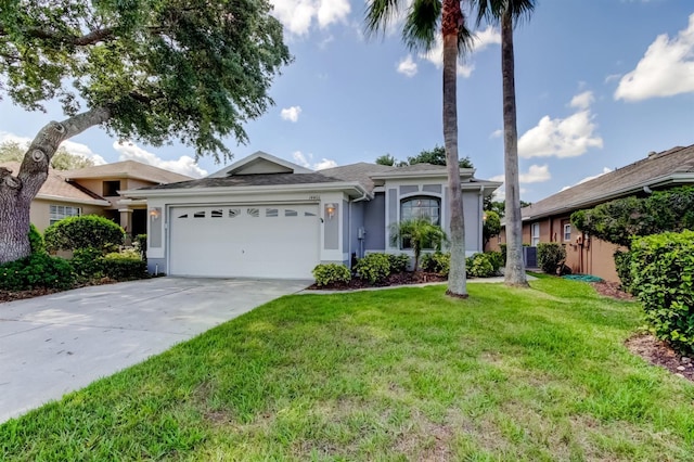 14466 Tamarind Loop, Spring Hill, FL 34609 - ranch-style home with an attached garage, concrete driveway, a front lawn, and stucco siding