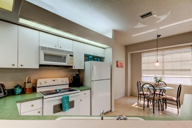 14466 Tamarind Loop, Spring Hill, FL 34609 - kitchen with white appliances, white cabinetry, pendant lighting, light tile patterned flooring, and a sink