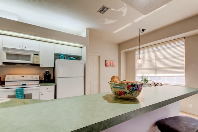 14466 Tamarind Loop, Spring Hill, FL 34609 - kitchen with white appliances, pendant lighting, and white cabinets