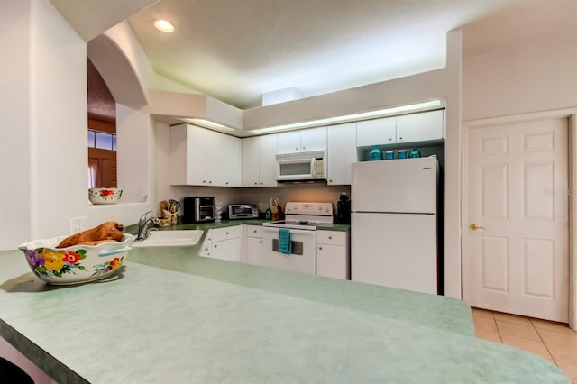 14466 Tamarind Loop, Spring Hill, FL 34609 - kitchen featuring white appliances, a sink, white cabinetry, light tile patterned flooring, and arched walkways