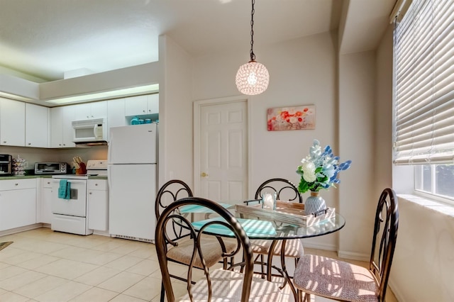 14466 Tamarind Loop, Spring Hill, FL 34609 - kitchen with white appliances, white cabinetry, light tile patterned flooring, pendant lighting, and dark countertops