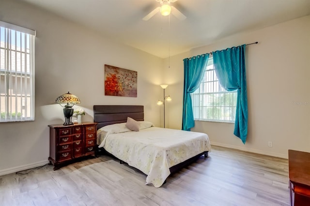 14466 Tamarind Loop, Spring Hill, FL 34609 - bedroom with multiple windows, light wood-style floors, baseboards, and a ceiling fan