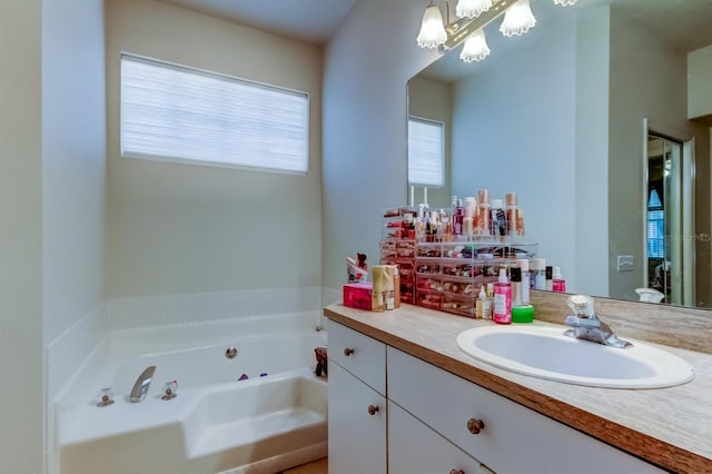 14466 Tamarind Loop, Spring Hill, FL 34609 - bathroom with a tub with jets, vanity, and a chandelier