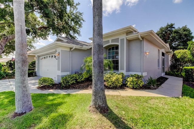 14466 Tamarind Loop, Spring Hill, FL 34609 - view of front facade featuring a garage, stucco siding, a front yard, and concrete driveway