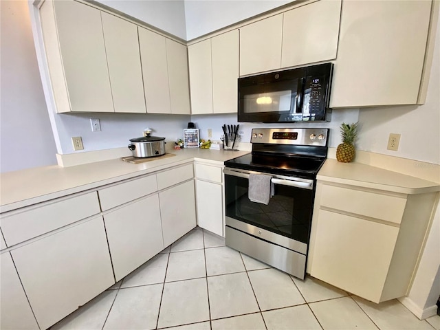 9200 Turnberry Ct, New Port Richey, FL 34655 - kitchen with black microwave, stainless steel electric range, light countertops, and cream cabinets