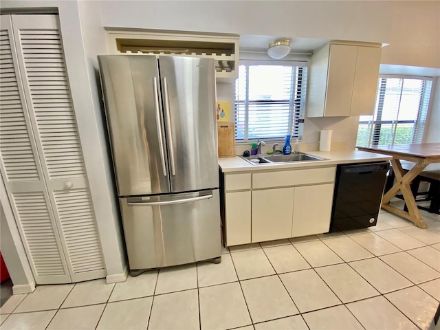 9200 Turnberry Ct, New Port Richey, FL 34655 - kitchen with freestanding refrigerator, black dishwasher, a sink, light countertops, and light tile patterned flooring