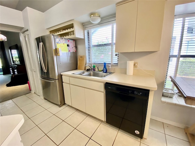 9200 Turnberry Ct, New Port Richey, FL 34655 - kitchen with black dishwasher, a sink, freestanding refrigerator, light countertops, and plenty of natural light
