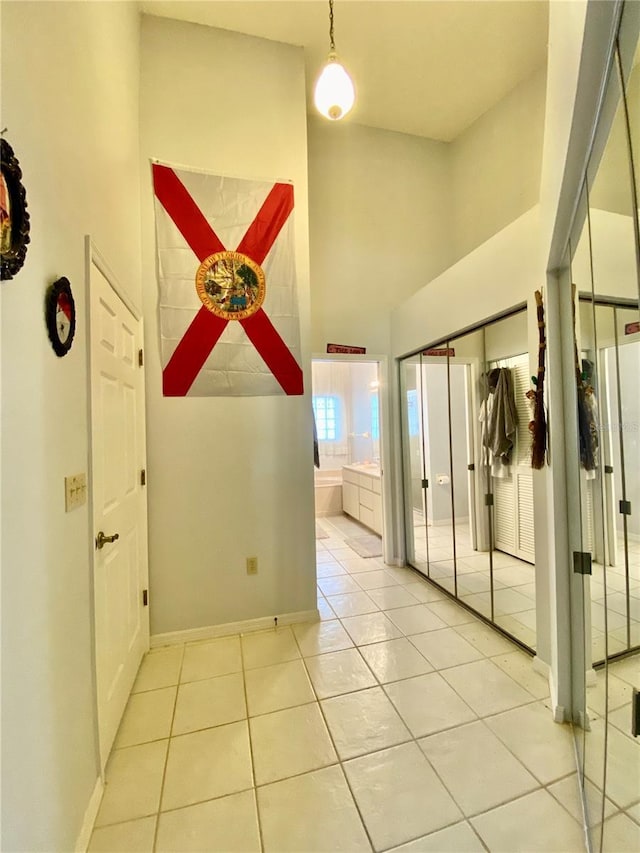 9200 Turnberry Ct, New Port Richey, FL 34655 - corridor featuring high vaulted ceiling, baseboards, and light tile patterned floors