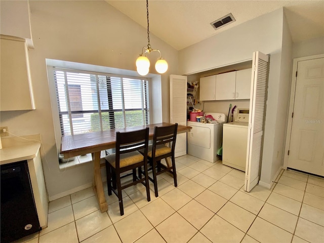 9200 Turnberry Ct, New Port Richey, FL 34655 - dining area featuring separate washer and dryer, light tile patterned floors, a chandelier, and high vaulted ceiling