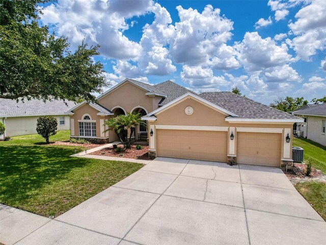 13248 Linzia Ln, Spring Hill, FL 34609 - view of front of house featuring stucco siding, an attached garage, and a front yard