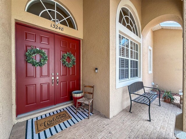 13248 Linzia Ln, Spring Hill, FL 34609 - doorway to property with stucco siding and covered porch