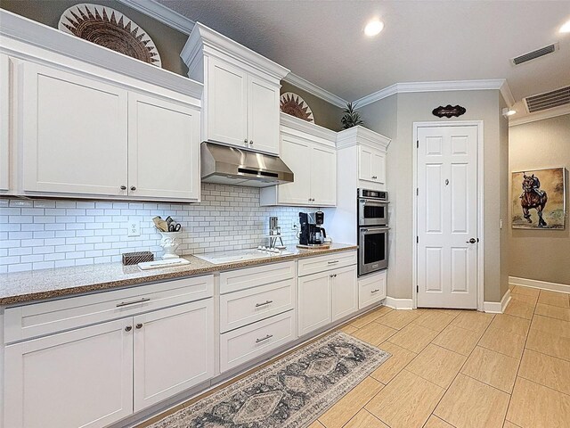 13248 Linzia Ln, Spring Hill, FL 34609 - kitchen featuring under cabinet range hood, ornamental molding, stainless steel double oven, tasteful backsplash, and white cabinetry