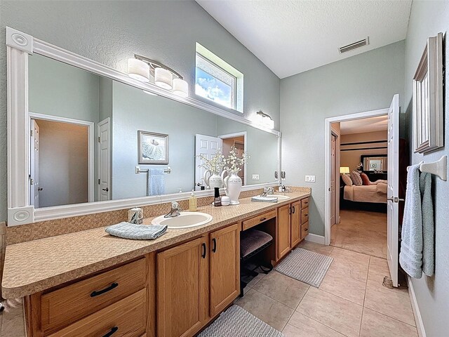 13248 Linzia Ln, Spring Hill, FL 34609 - bathroom with ensuite bathroom, double vanity, tile patterned flooring, and a textured ceiling